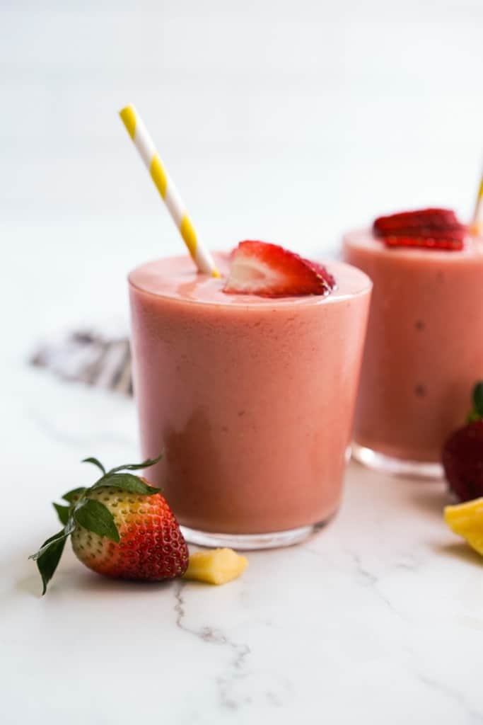 Thick Mango strawberry smoothie filled to the brim in a glass
