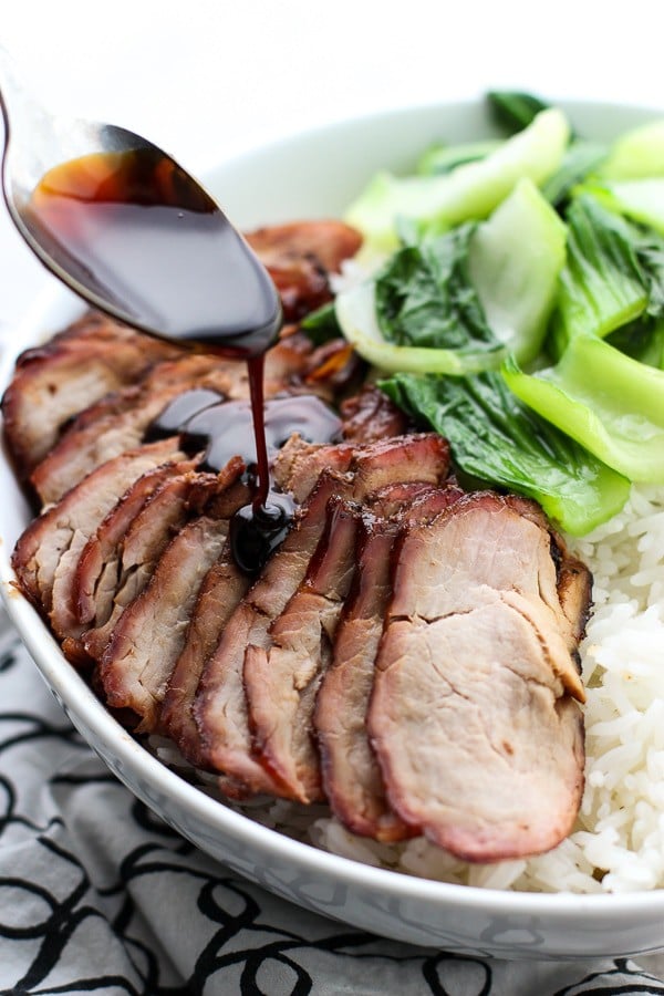 Drizzling sauce onto Chinese Barbecue Pork (char Siu) and Bok Choy Rice Bowl