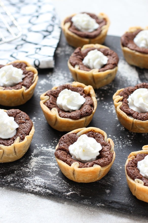 A tray of Mini Chocolate Chess Pie with whipped cream on top