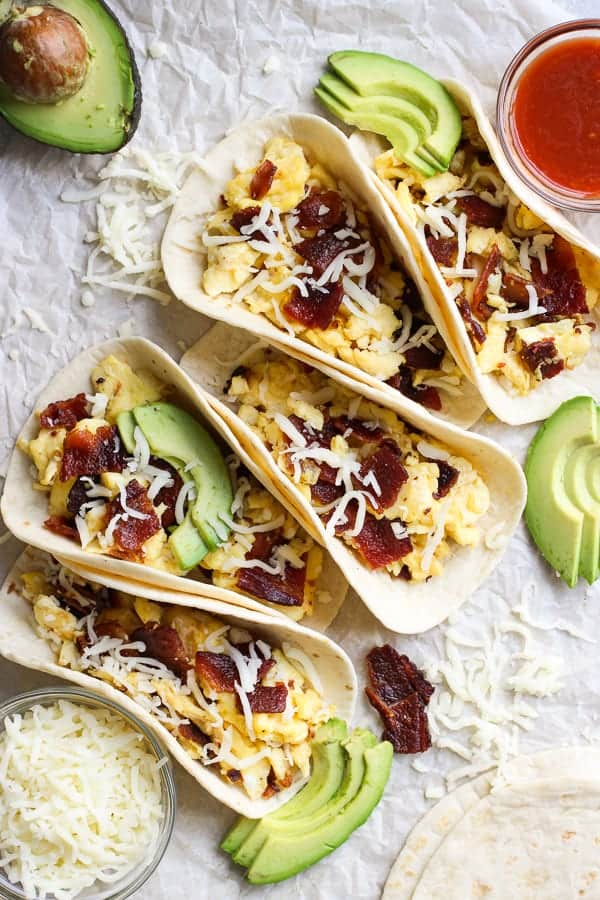 Breakfast Tacos filled with scrambled eggs, bacon and avocado, with salsa and cheese