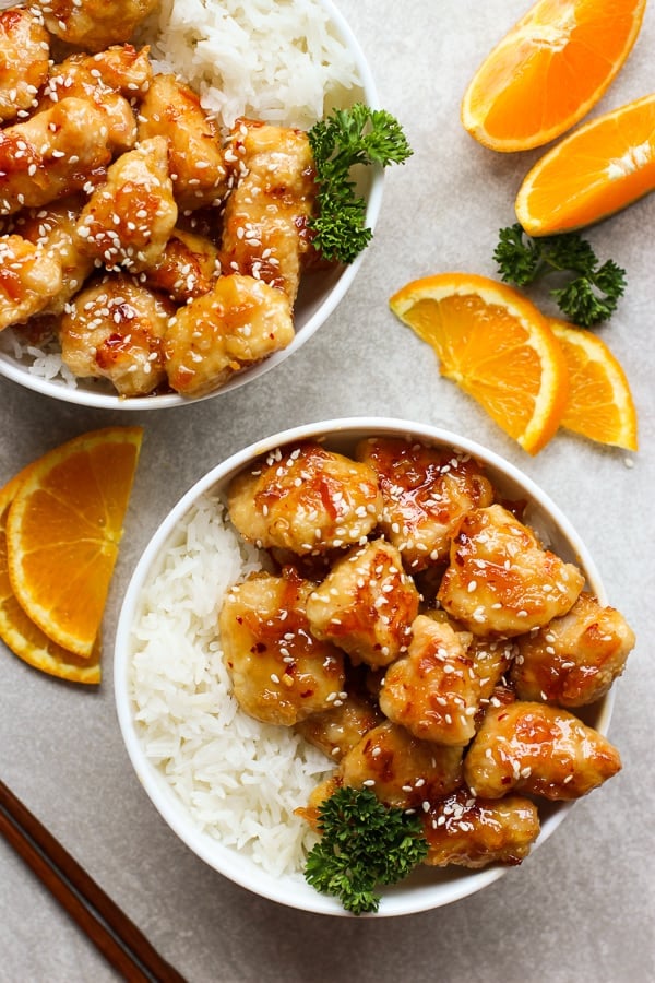 Two bowls of Easy Baked Orange Chicken served with rice