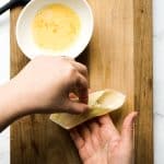 Folding wonton wrapper around cream cheese filling