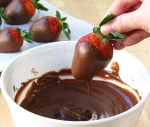 Dipping strawberry into melted chocolate. YUM!