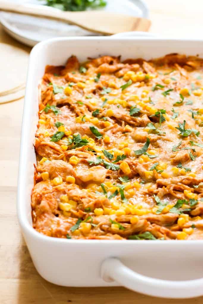 A large rectangular baking dish of chicken enchilada casserole