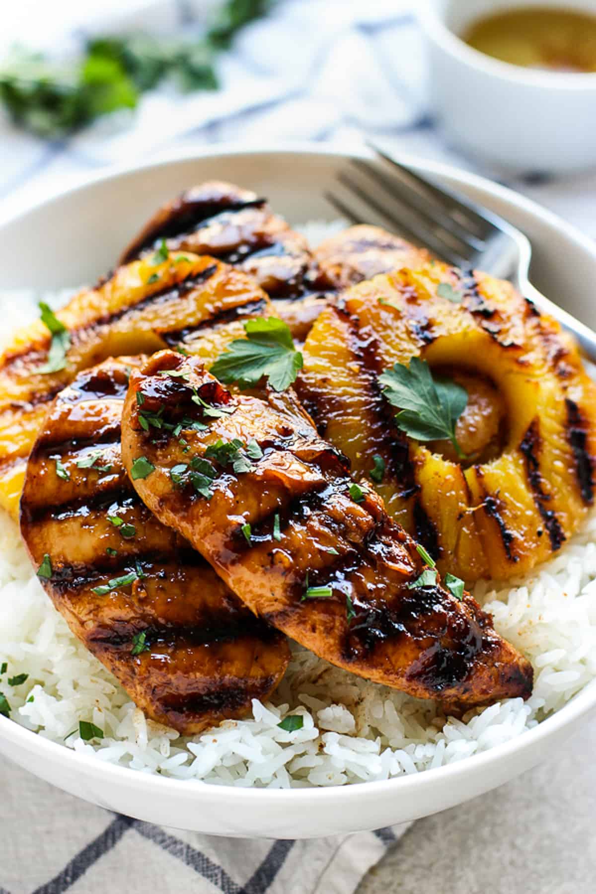 A bowl of Hawaiian Chicken and pineapple on top of a bed of Coconut Rice