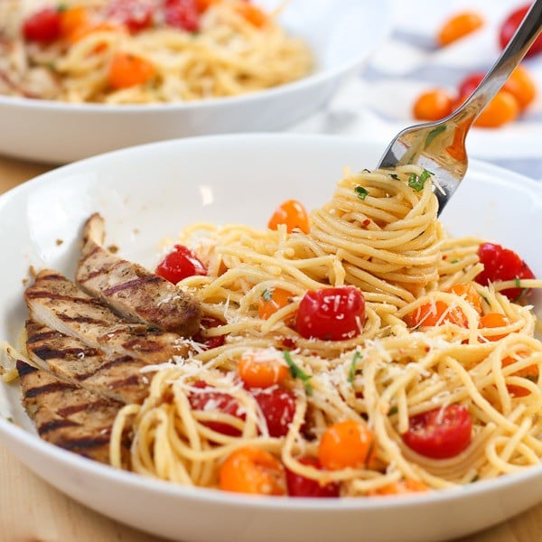 Using a fork to dig into Cherry Tomato Basil Pasta with Chicken