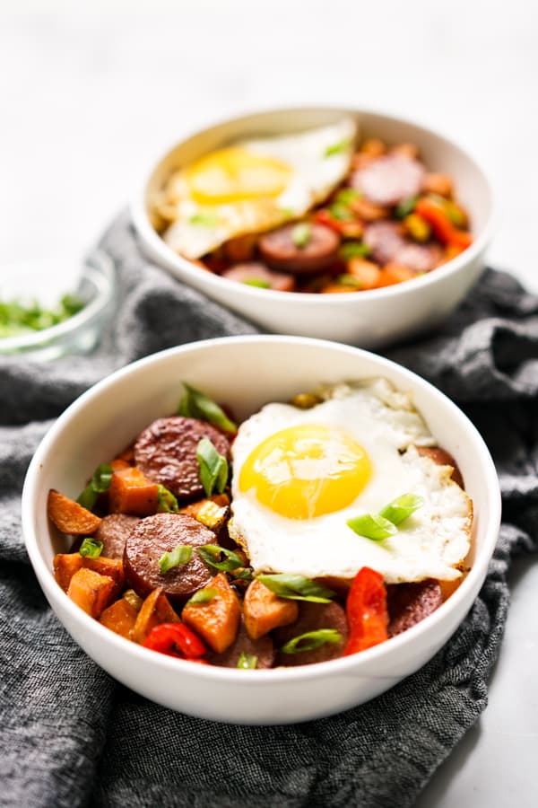 A bowl of Sweet Potato Breakfast Hash with a sunny side up egg on top