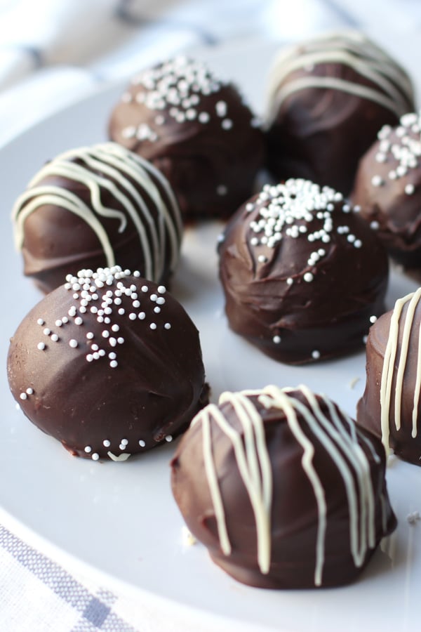 CLoseup of oreo truffles coated in chocolate with sprinkles or white chocolate on top