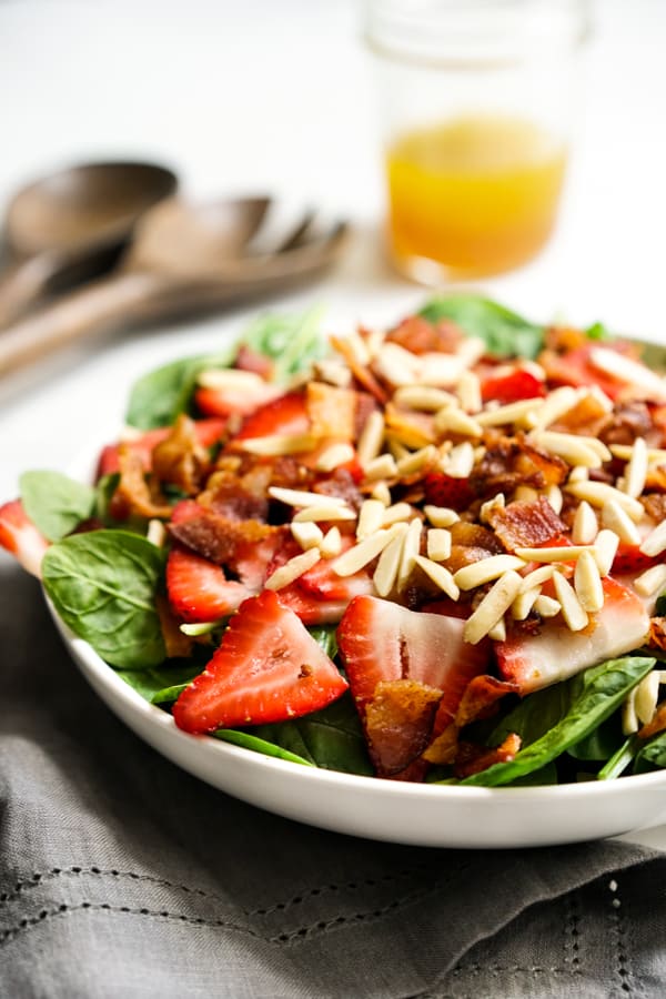 Strawberry Bacon Spinach Salad with Lemon Maple Dressing in the background