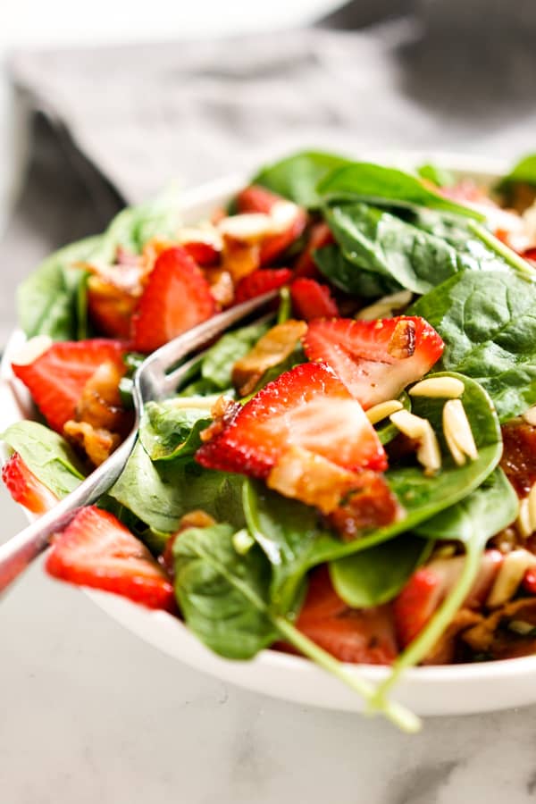 Fork digging into strawberry spinach salad