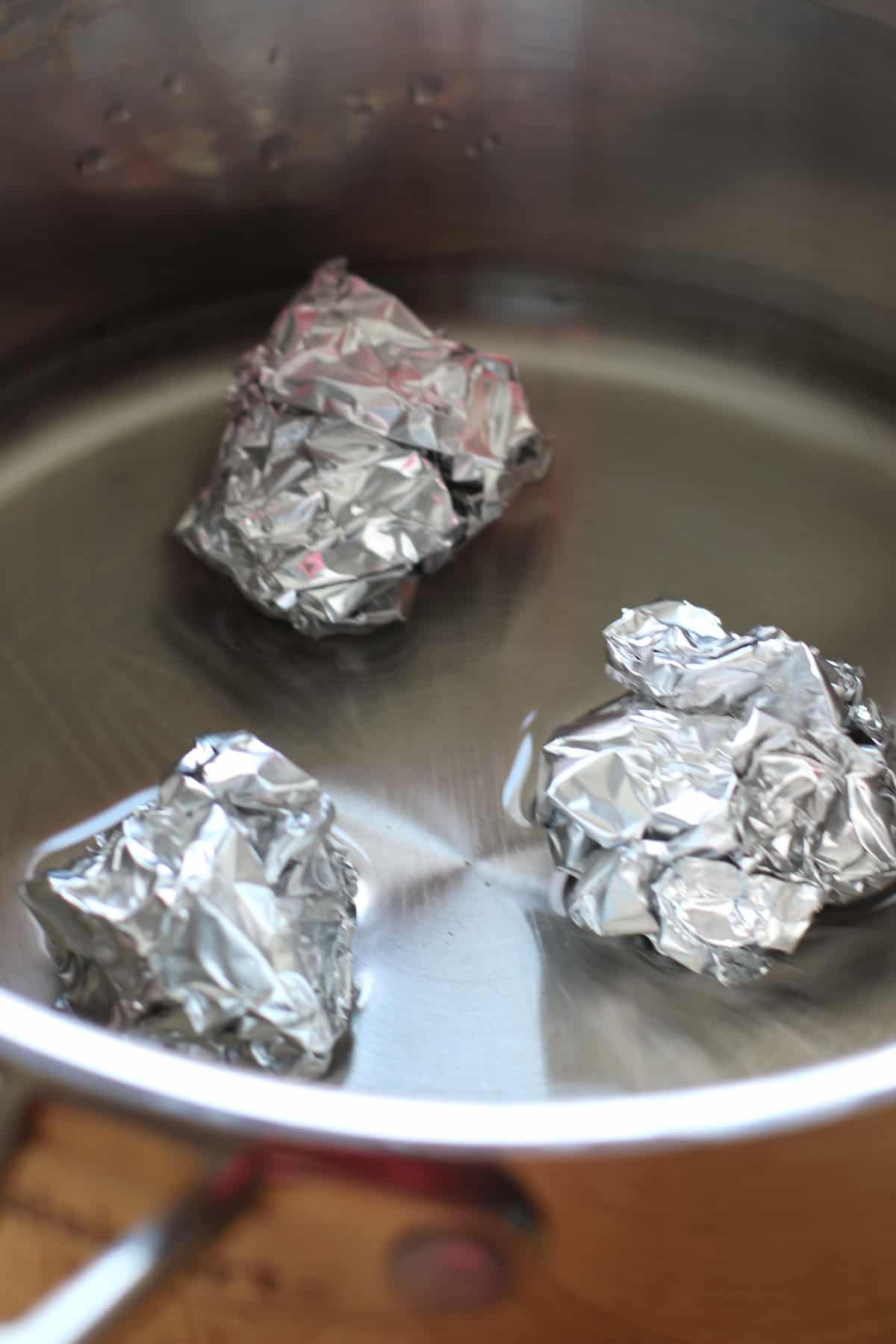 aluminum foil balls at the bottom of the pot filled with water