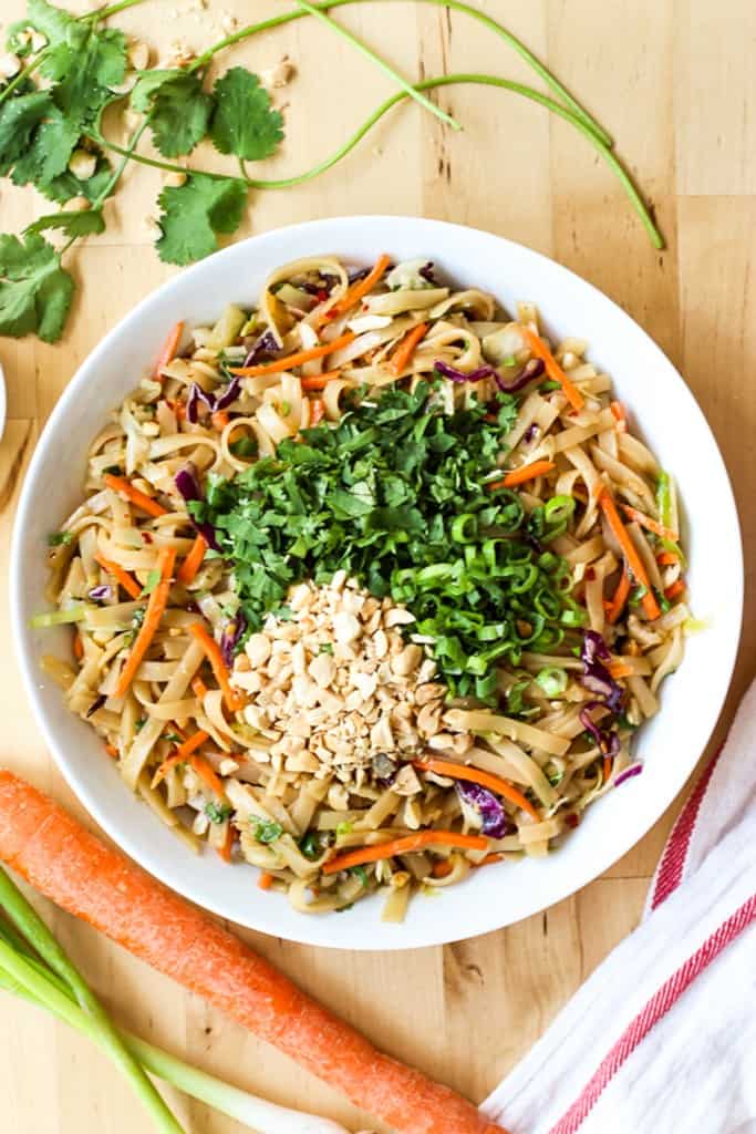 A bowl of thai noodle salad topped with peanuts and cilantro