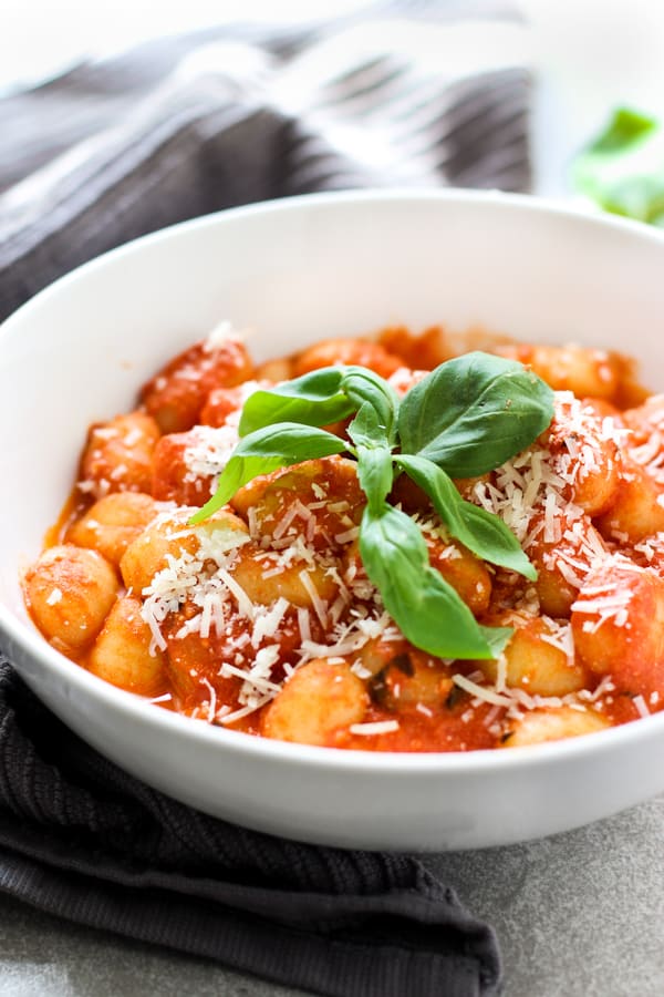 A bowl of gnocchi with tomato basil sauce
