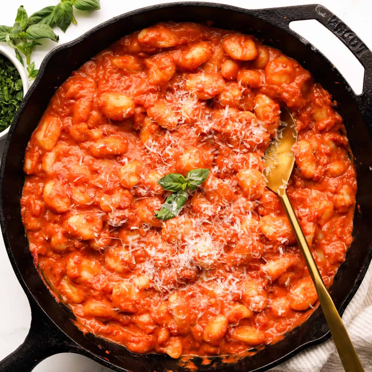 Gnocchi coated in creamy tomato sauce in a large cast iron skillet
