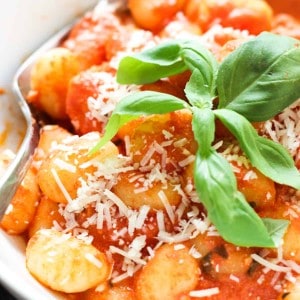closeup of gnocchi in tomato sauce with basil on top