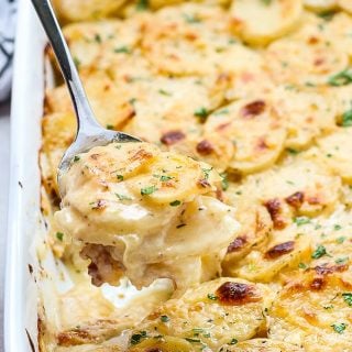 Scooping a spoonful of Cheesy Garlic Scalloped Potatoes