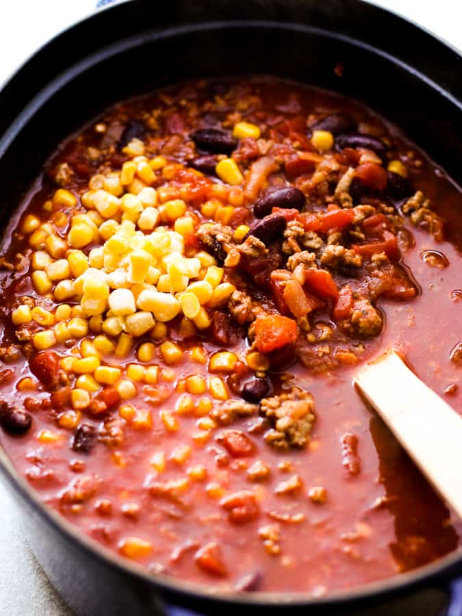 Cooking chili loaded with black beans, tomatoes and corn in a chunky tomato base broth.