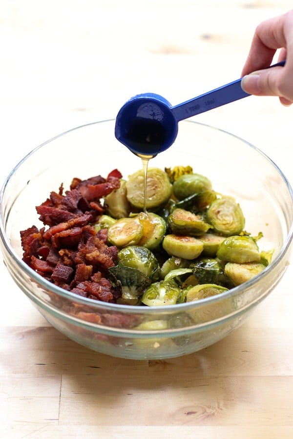 Drizzling honey into the Honey Roasted Brussel Sprouts and Bacon dish