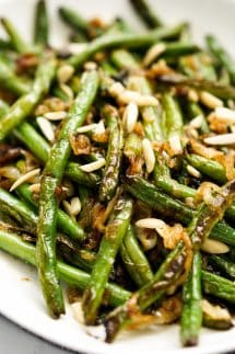 A plate of green beans topped with caramelized onions