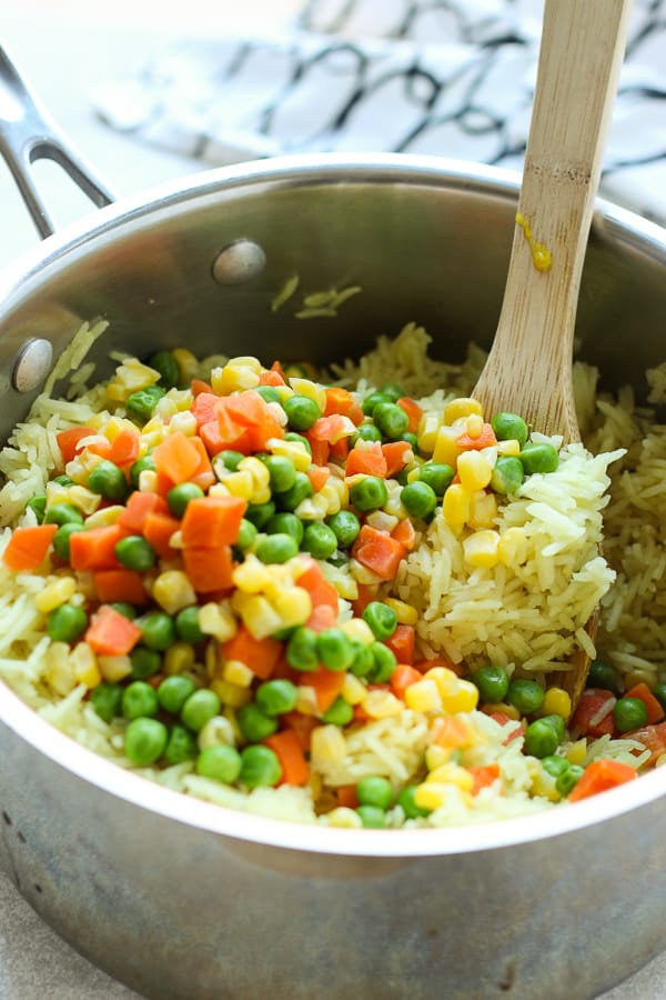 Arroz mixto de verduras fácil en una olla con espátula de madera