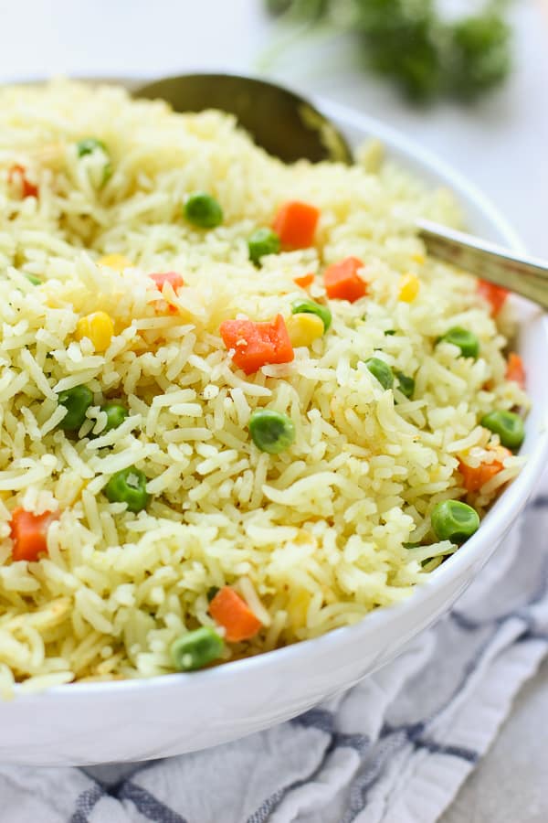 A big bowl of Easy Mixed Vegetable Rice with a spoon in it