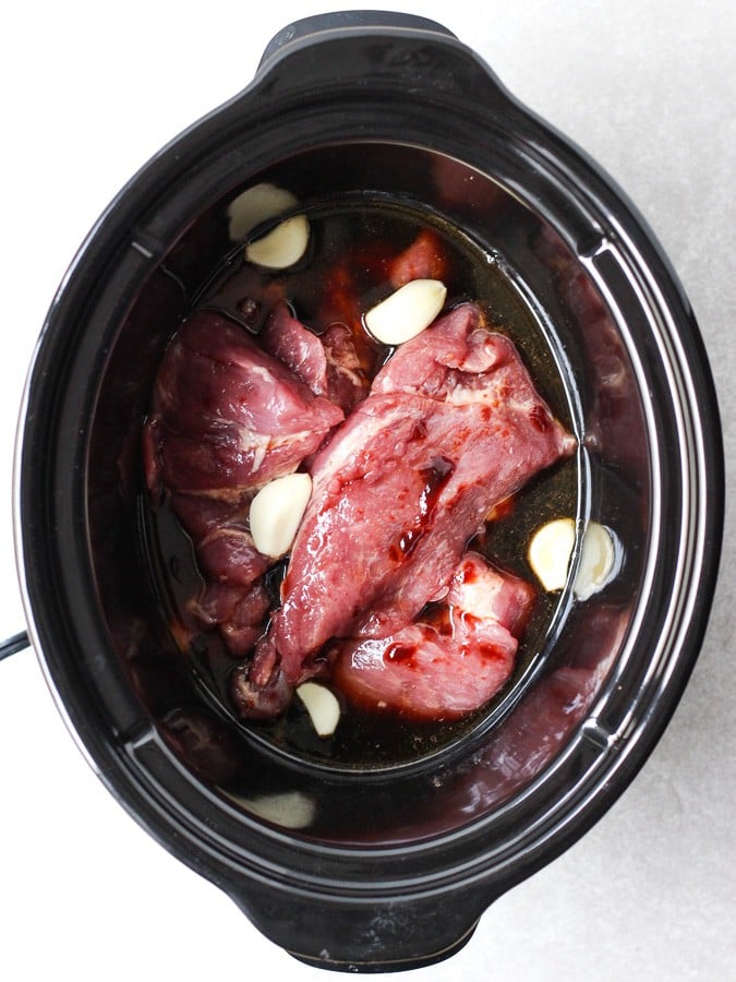 Uncooked Slow Cooker Asian Shredded Pork in slow cooker along with sauces and spices