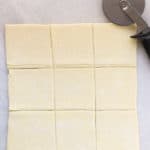 Cutting puff pastry into 9 squares for Sausage and Cheese Puff Pastry Pockets