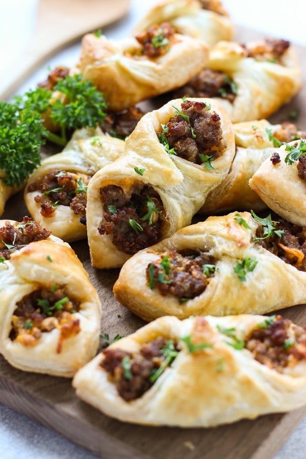 Many Sausage and Cheese Puff Pastry Pockets on a cutting board