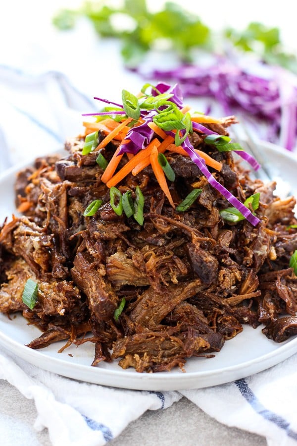 Slow Cooker Asian Shredded Pork with garnishes on a plate