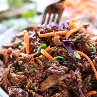 Slow Cooker Asian Shredded Pork on a plate, with a fork digging into it