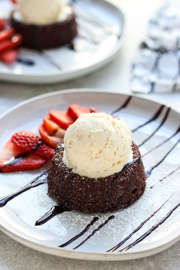 Molten Chocolate Lava Cake plated with strawberries and chocolate syrup