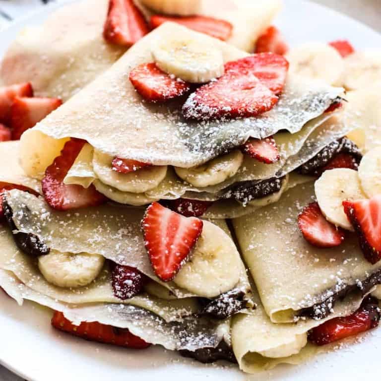 A plate of strawberry banana nutella crepes