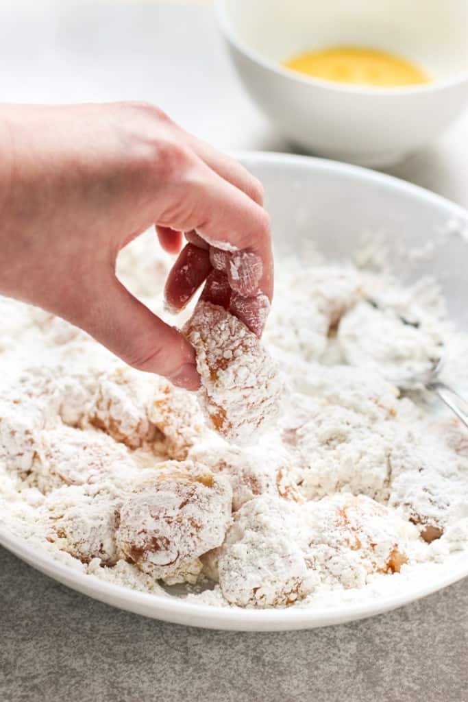 dipping chicken pieces into flour mixture