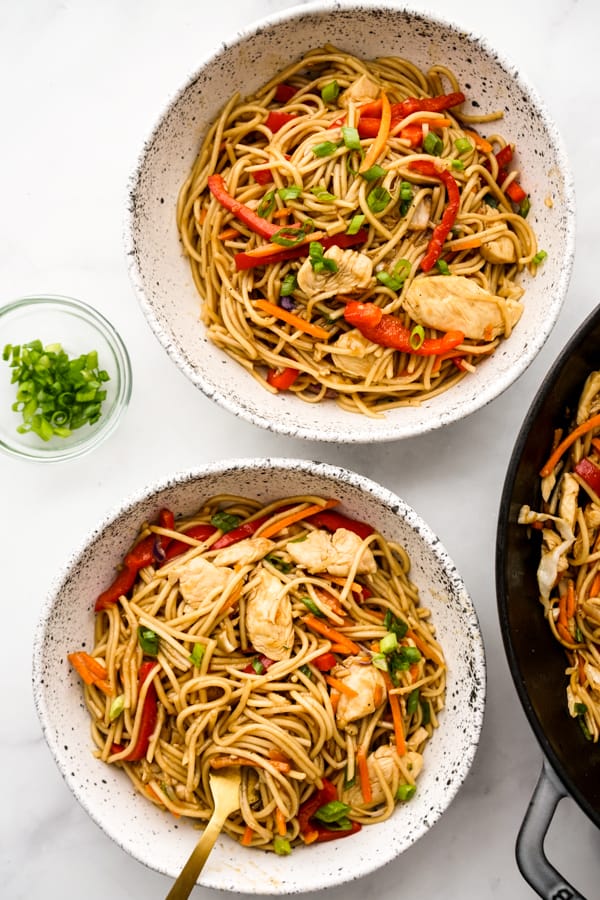 A bowl of Chicken Lo Mein with chopsticks in the background