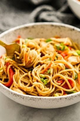 Using a fork to dig into a bowl of Chicken Lo Mein