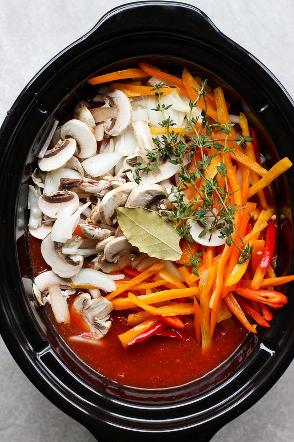 A crockpot of uncooked Slow Cooker Tomato and Herb Chicken