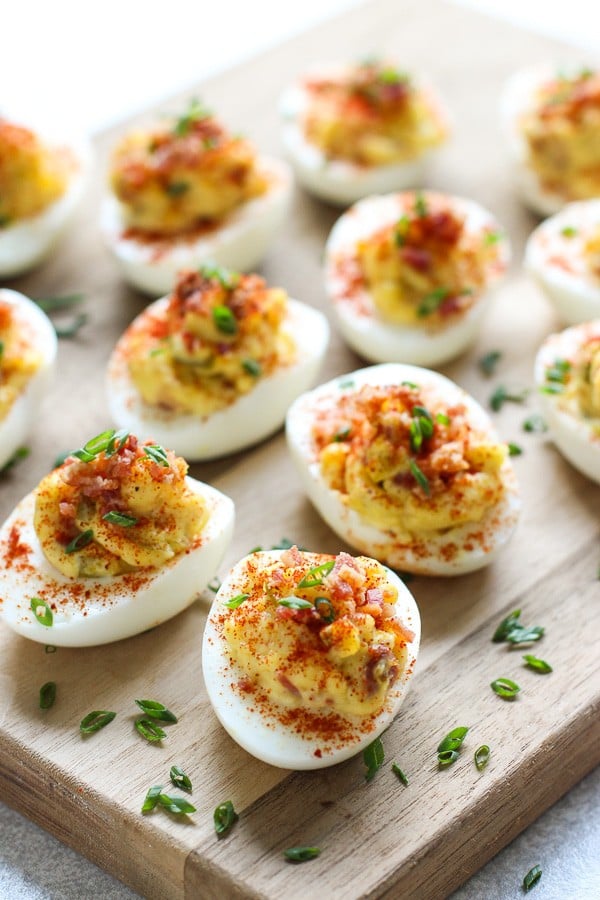 Lots of Bacon Deviled Eggs on a wooden board