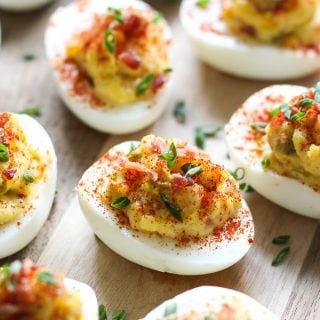 Upclose shot of Bacon Deviled Eggs on a wooden board