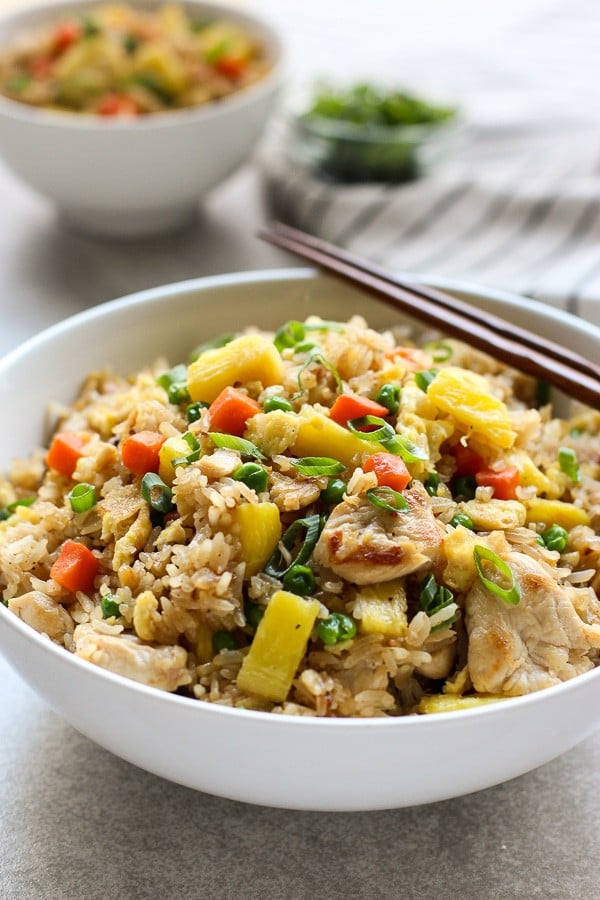 A bowl of Thai Pineapple Fried Rice with chopsticks on the bowl