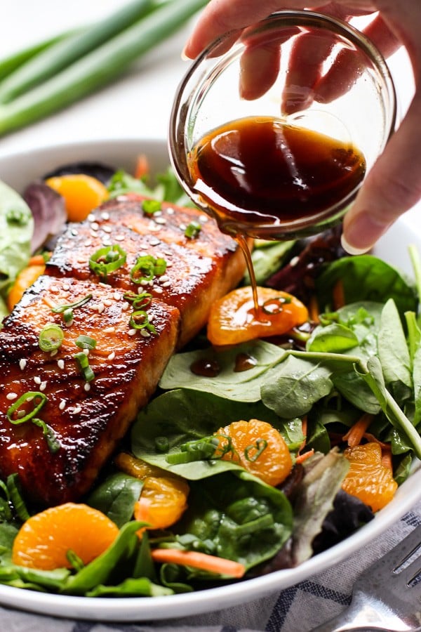 Pouring dressing over Asian Salmon Salad