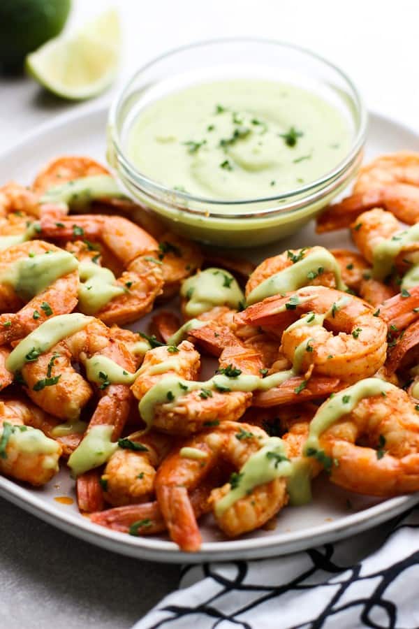 A plate of Chili Lime Shrimp with a bowl of avocado cream 