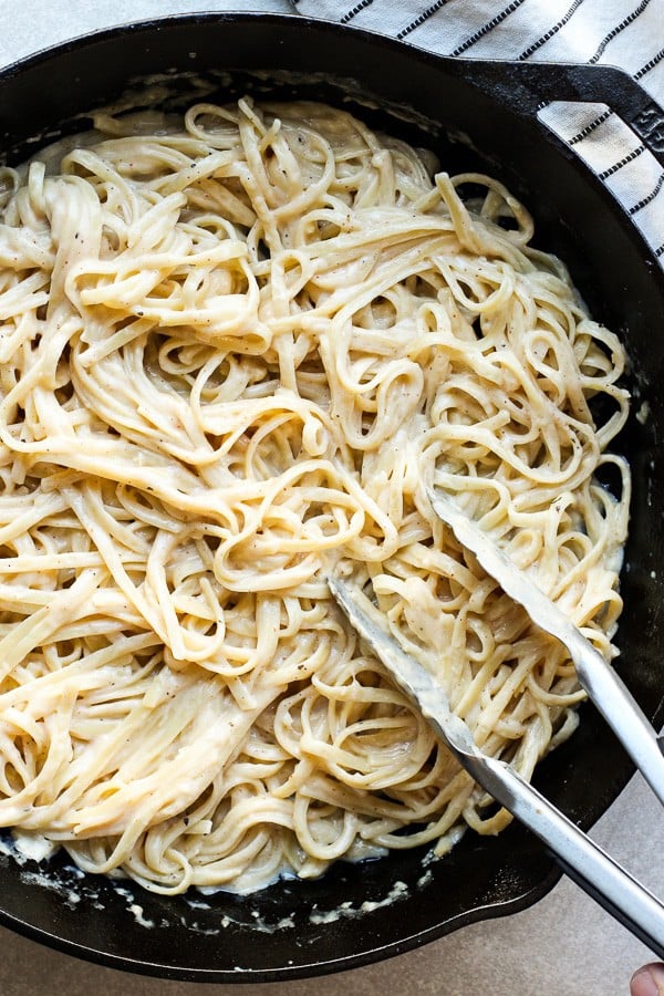 Use a pair of tongs to toss noodles in creamy sauce