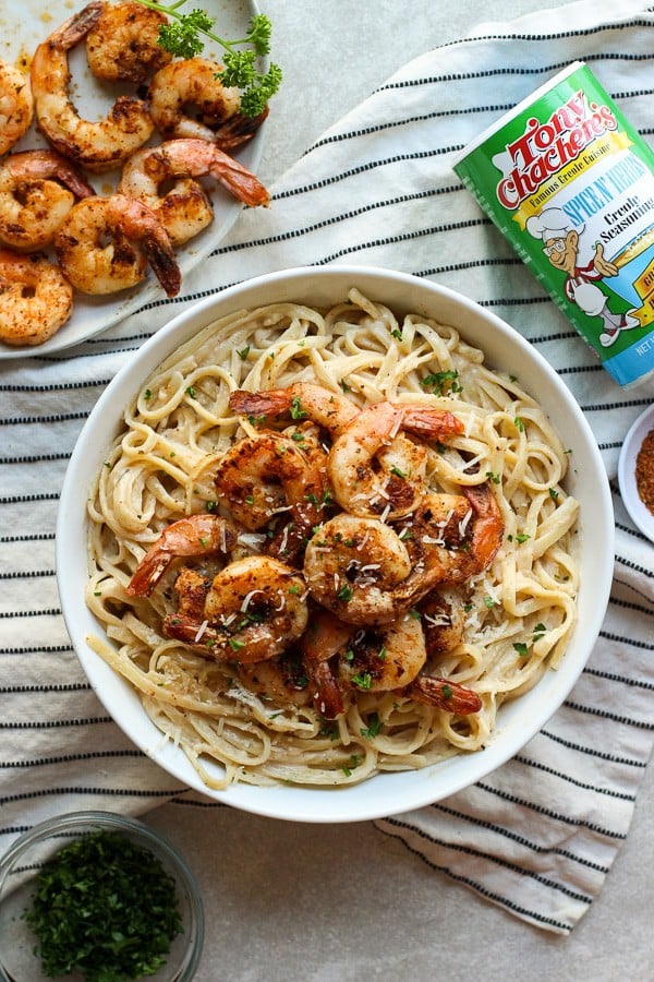 A bowl of Blackened Shrimp Pasta with Tony's seasoning on the side