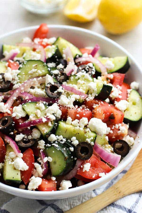 A large bowl of cucumber, tomatoes, red onions and olives tossed in Greek Lemon dressing. 