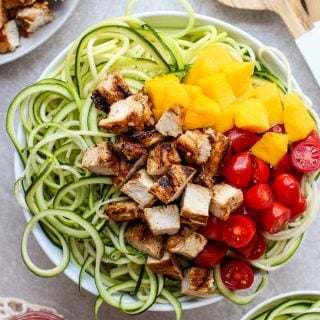 A bowl of Grilled Chicken Zoodles with BRIANNAS blush wine vinaigrette on the side