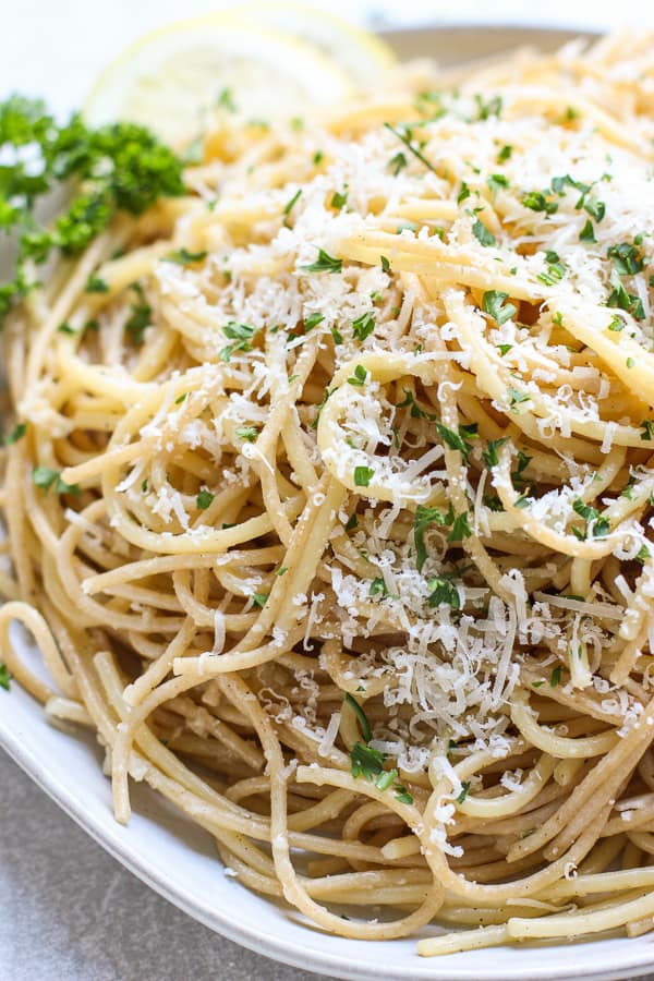 Upclose of a plate of spaghetti tossed in lemon, garlic, butter and parmesan cheese