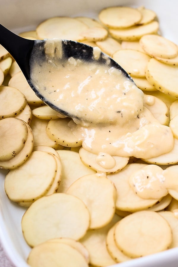 Adding cheese sauce to potatoes