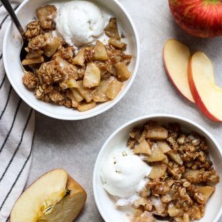 To bowls of Easy Apple Crisp topped with vanilla ice cream