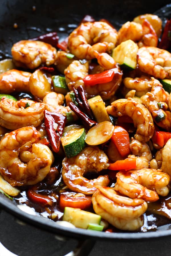 Pan frying shrimp, zucchinis, bell peppers in the skillet