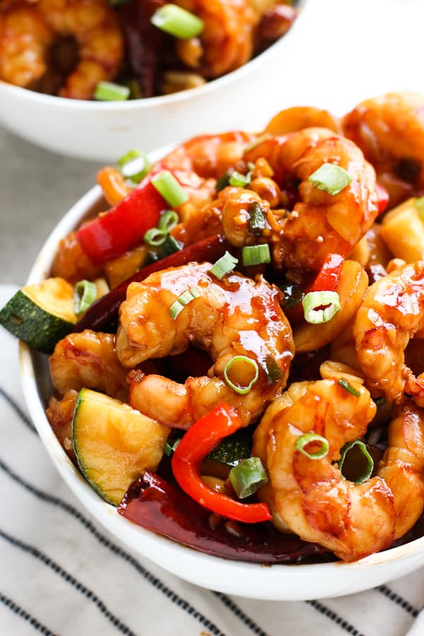 A closeup bowl of Kung Pao Shrimp with zucchinis and bell peppers